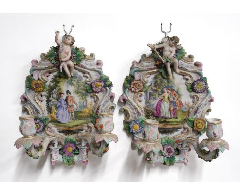 A PAIR OF GERMAN PORCELAIN TWIN-LIGHT CANDLE SCONCESLate 19th centuryEach painted with a courting couple in a landscape, insi
