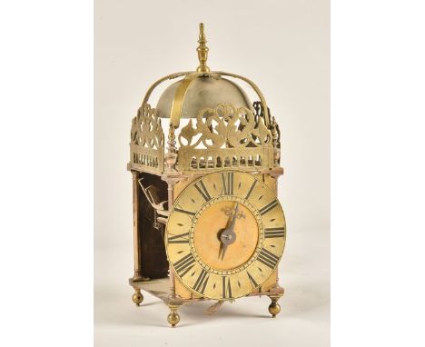 A BRASS STRIKING LANTERN CLOCKSurmounted by a turned brass finial and bell with four-piece strap, above pierced frets, the 6 