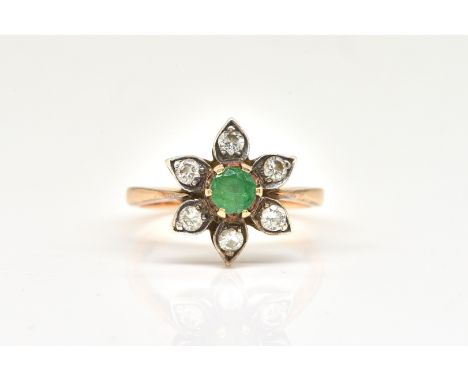 A GOLD, EMERALD AND DIAMOND FLOWER CLUSTER RINGWith the central round faceted emerald, surrounded by six round brilliant cut 