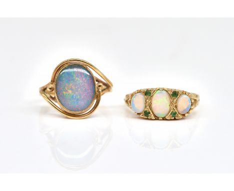 TWO GOLD AND GEM SET RINGS (2)Comprising; a 9ct gold ring mounted with three oval opals and with two pairs of small emeralds 