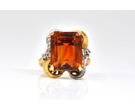 A GOLD, CITRINE AND DIAMOND RINGClaw set with a rectangular step cut citrine, between diamond set scrolling shoulders mounted