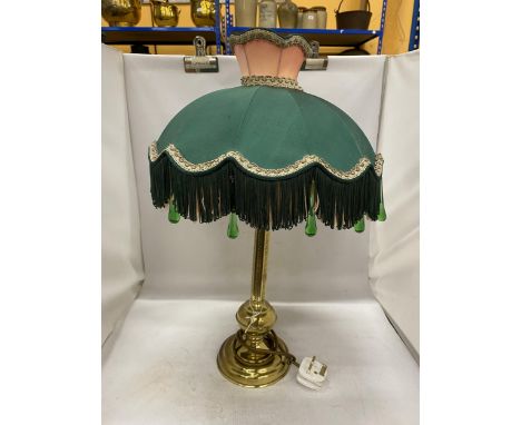A DECORATIVE BRASS LAMP BASE AND A VICTORIAN STYLE GREEN AND PINK FABRIC SHADE WITH FRINGE AND GREEN GLASS DROPS