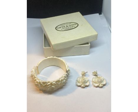 A CARVED IVORY COLOURED BANGLE AND EARRINGS SET IN A PRESENTATION BOX