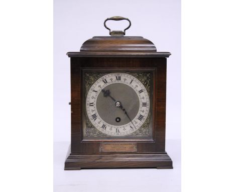 A VINTAGE MAHOGANY CASED MANTLE CLOCK WITH A PLINTH TO THE FRONT DATED 1945, WITH KEY