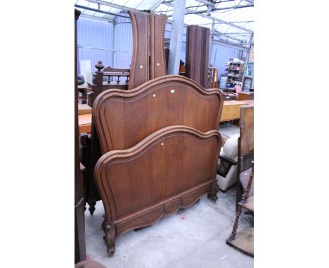 A CONTINENTAL OAK 4'6" BEDSTEAD WITH ARCHED TOPS AND FOLIATE CARVINGS