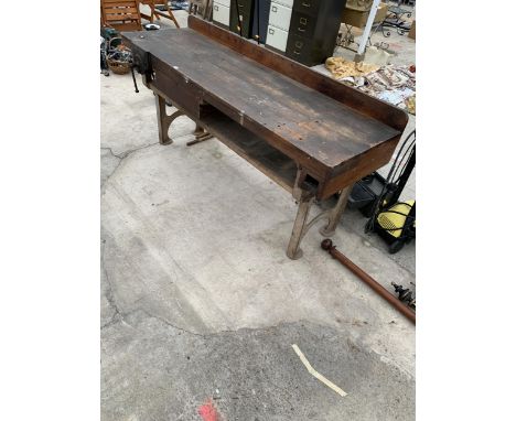 A LARGE HEAVY DUTY VINTAGE WORK BENCH WITH CAST RION BASE, LOWER DRAWER AND A PARKINSONS WOOD VICE