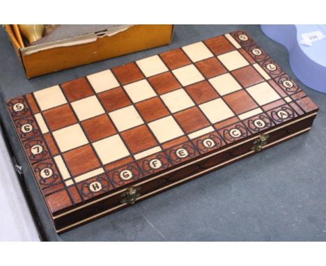 A WOODEN CHESSBOARD AND A FULL SET OF CHESS PIECES