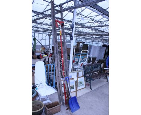 A VINTAGE WOODEN EXTENDING LADDER AND AN ASSORTMENT OF GARDEN TOOLS