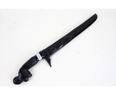 Oceanic hardwood knife, with a carved handle and scabbard, the blade marked Manap, 63cm long