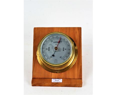 Sestrel brass cased marine barometer, the silvered dial inscribed "CAP'T O.M. WATTS LTD. LONDON", on a later wooden slope mou