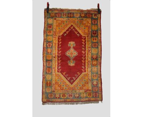 Two Anatolian rugs, the first a Kula rug, central Anatolia, early 20th century, 4ft. 10in. X 3ft. 1in. 1.47m. X 0.94m. Red lo