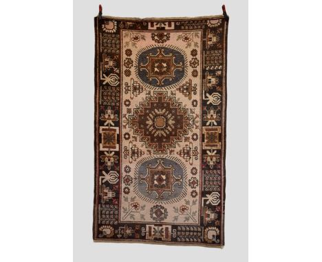 Yarkand rug, east Turkestan, first half 20th century, 7ft. 11in. X 4ft. 7in. 2.41m. X 1.40m. Cream field with three centrew m