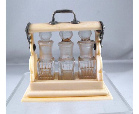 A late 19thC miniature novelty ivory perfume bottle Tantalus containing three bottles 7cm high Condition ReportThere is a sma