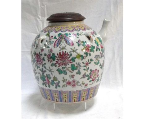 A large Chinese famille rose tea pot, decorated butterflies and flowers in enamel colours with an associated pierced wooden c