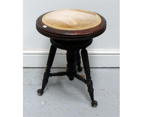 A late 19thC circular revolving piano stool on ring turned legs with cast claw and ball feet 35cm diameter 