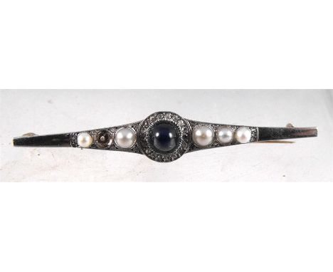 A yellow metal bar brooch set with a large central sapphire cabochon encircled with diamonds and flanked with pearls (missing