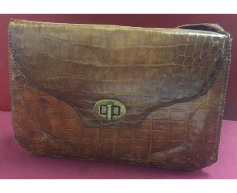 A vintage crocodile skin handbag with soft leather interior.