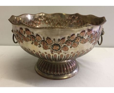 A silver on copper vintage punch bowl with floral garland decoration.
