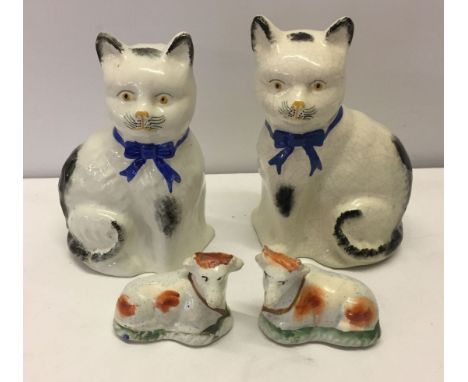 A pair of Staffordshire ceramic cows together with a pair of vintage ceramic cats - paintwork retouched on one.