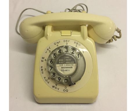 A vintage cream telephone, wired for use.