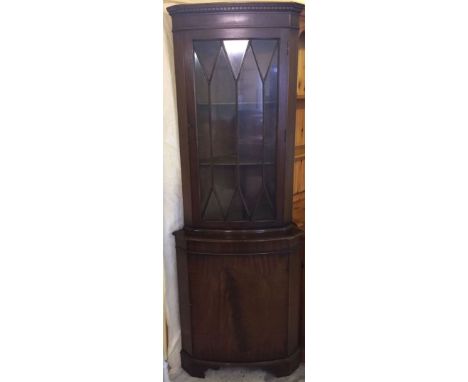 A dark oak corner unit, glazed front shelf unit to top with single cupboard base. Total height 180cm.