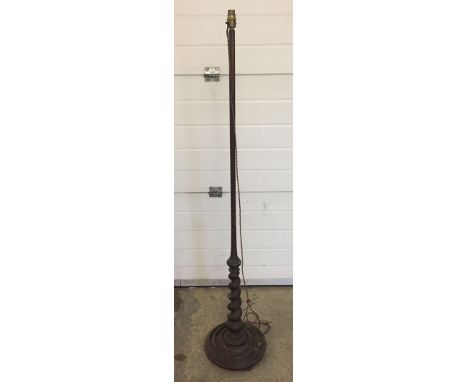A dark wood standard lamp base with barley twist decoration.