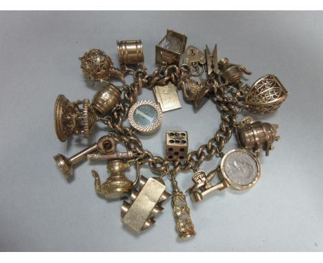 A 9ct gold charm bracelet with twenty-two charms, the curb link bracelet with heart locket clasp suspending various unusual c