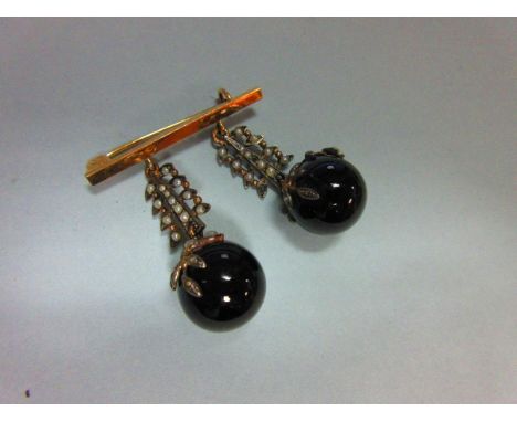 A bar brooch set with a pair of seed pearl and black coral pendants, each pendant with a 14mm polished black coral sphere cla