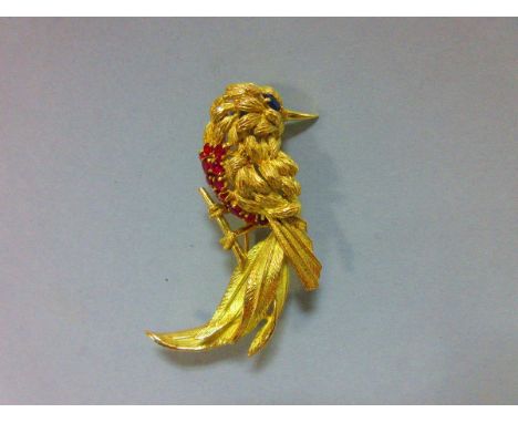 A ruby and sapphire bird brooch, the realistically modelled exotic bird with textured feathers, oval cut sapphire eye and bre