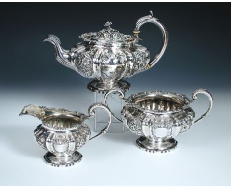 A William IV silver three piece tea set by Edward Barton, London 1833, comprising a teapot of compressed melon shape, lobed a