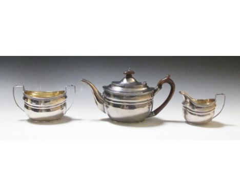 A silver three piece tea set, by Charles Stuart Harris, London 1927, comprising:- a teapot of compressed oval form with mould