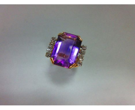 An amethyst and diamond ring, set with an octagonal step cut amethyst measuring 1.9 x 1.3cm, between lines of old approximate