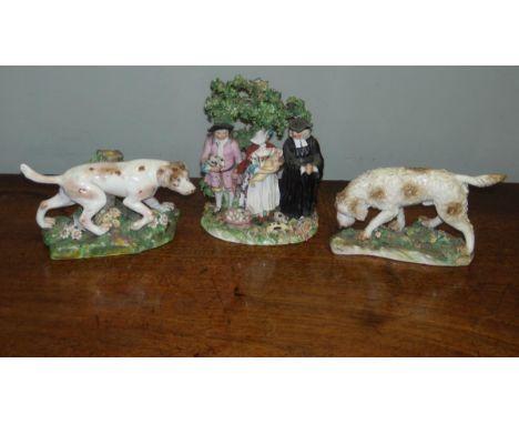 Two patch marked Derby figures of dogs and a tythe group, the liver and white dog on point, 17cm (6.75 in) wide and the curle