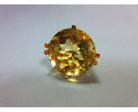 A single stone lemon citrine dress ring, the round cut pale yellow stone, diameter 2.1cm held by square section claws above a