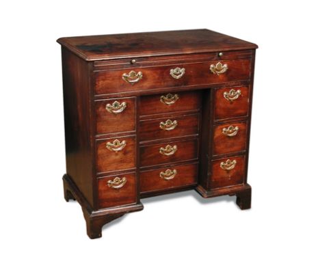 A George III mahogany kneehole desk, with brushing slide, one long drawer and ten small drawers, the central movable bank of 