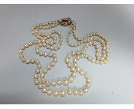 A two row pearl necklace with ruby and diamond clasp, the 3.6 - 8.0mm graduated pearls, to a navette shaped clasp set with a 