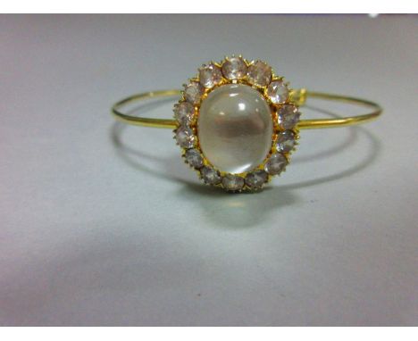 A moonstone and white hardstone cluster bangle, the sliding overlapping wires of the bangle set to the front with a large ova