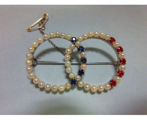 A ruby, sapphire and pearl double hoop brooch, each intersecting hoop formed by a single close set line of 3mm pearls alterna