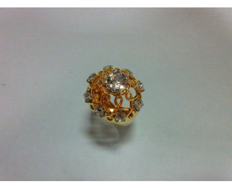 An unusual modern diamond ring, the pierced boss formed by twisted wires and set with a central and eight outer smaller old c