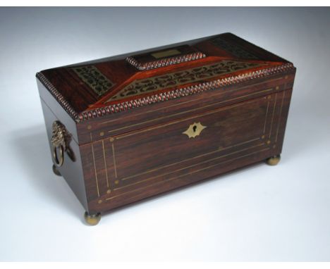 A Regency rosewood and cut brass inlaid tea caddy, the sarcophogus form with hinged lid opening to reveal two lidded compartm