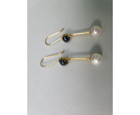 A pair of sapphire and pearl earpendants, the front of each wire hook with a round cabochon deep blue sapphire suspending a k