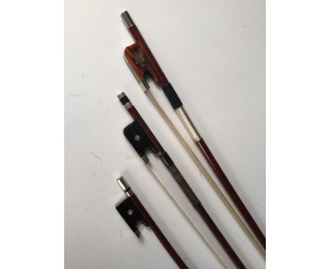 Three musical bows, comprising a violin bow with squared frog and white metal mounts, a viola bow with mother-of-pearl and ni