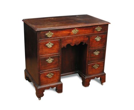 A George III mahogany kneehole desk, fitted a central cupboard, brass plate handles, on bracket feet 81 x 90 x 49cm (32 x 35 