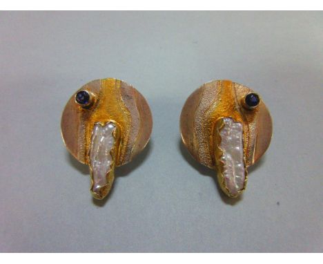 A pair of contemporary freshwater pearl and iolite earstuds, each designed as a slightly undulting disc of bicoloured metal w