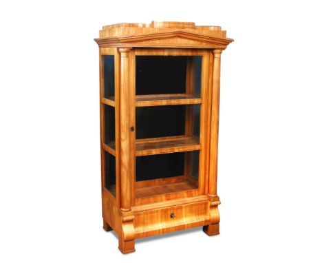 A Biedermeier satinwood display cabinet of architectural design, with drawer to base, column sides, on block feet 161 x 88 x 