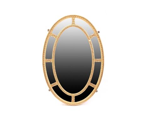 A George III style carved wood and gilt gesso oval wall mirror, late 19th/20th century. with bevelled plates and segmented bo