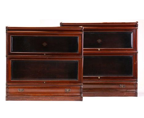 A pair of two-section mahogany Globe Wernicke modular bookcases with bevelled edge plain glazing and a frieze drawer to each 