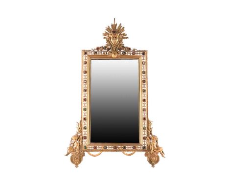 An Edwardian gilt brass and "Jewelled" easel dressing table mirror with radiant "Mask of Apollo" cresting above a bevelled pl