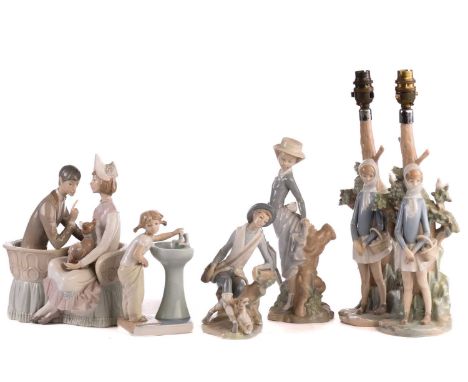 Two Lladro figural table lamp bases, each modelled with a girl holding a basket, 39 cm high, together with four further Lladr
