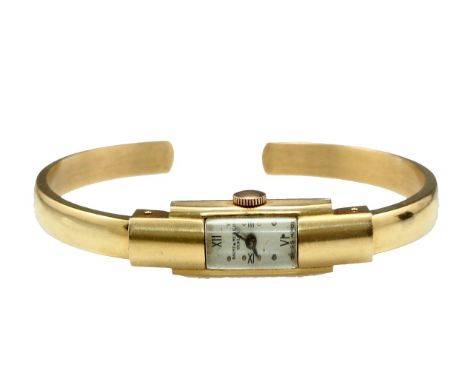 An 18K gold women's wrist watch by Baume & Mercier. Total weight: 20.8 grams. Minor flaw to gold bangle bracelet. In working 